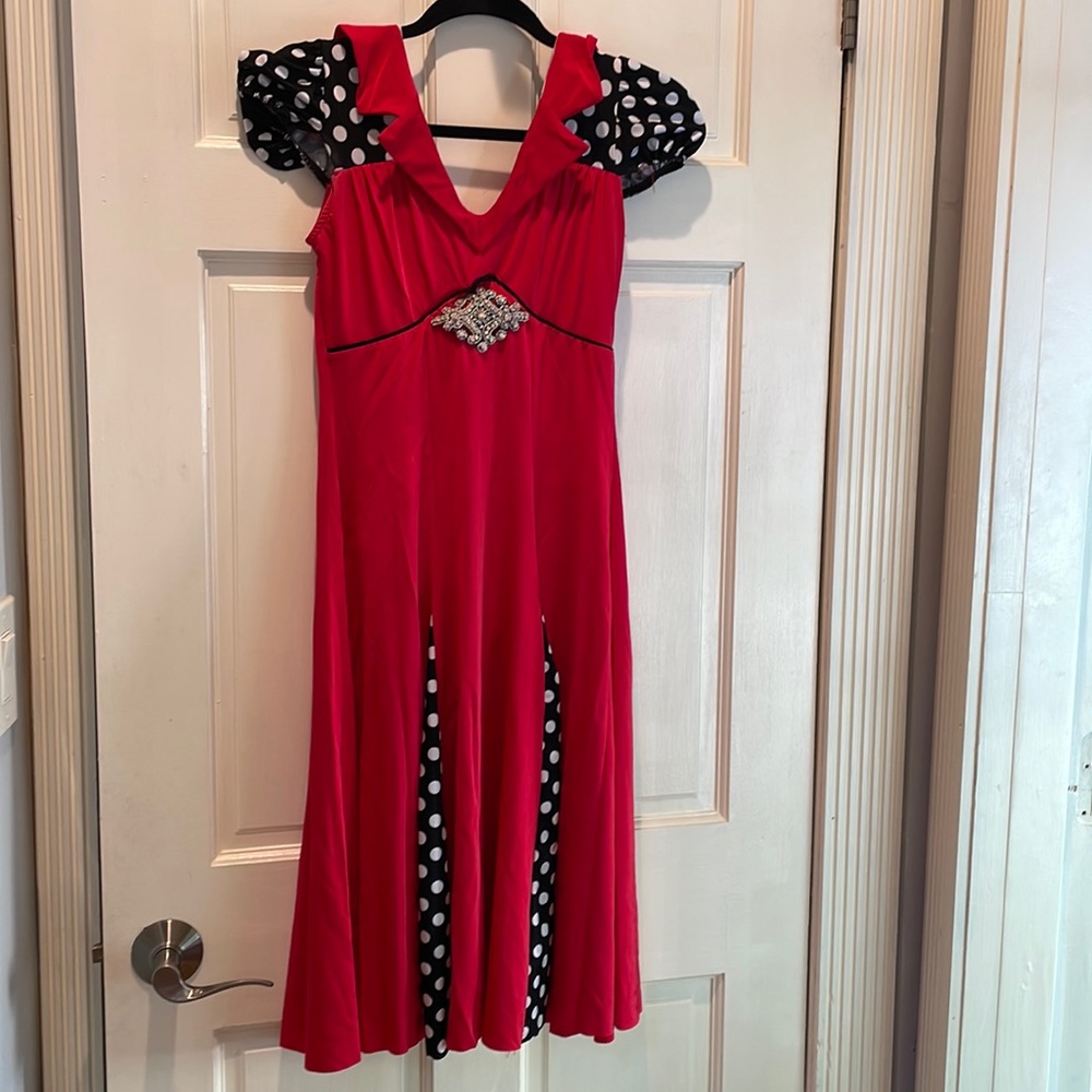 Red costume with black and white polka dot accents. Custome appliqué at waist.